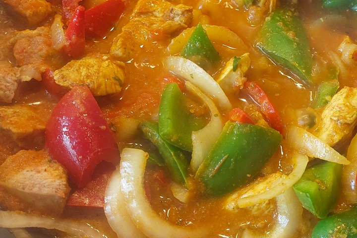 A vibrant dish featuring tender chicken, colorful bell peppers, and onions simmered in savory sauce. Perfect for dinner!
