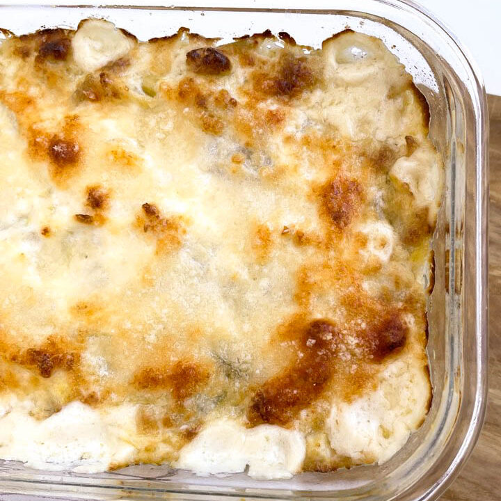 Bubbling cheesy casserole in a glass dish, golden brown on top, perfect for a cozy family meal or gathering.
