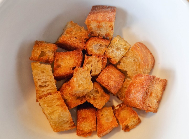 Bowl of golden brown, crunchy croutons, perfect for adding texture to salads and soups.